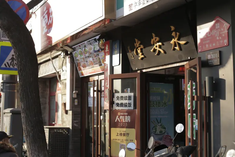 A neighborhood restaurant storefront with an open door, menu signs, and scooters outside.